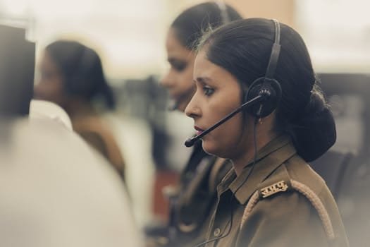 Ghidul Esențial pentru Marinari: Cum să Găsești Ușor Jobul Perfect pe Platformele Maritime 4 A focused Indian woman police dispatcher operating a headset in an office setting.