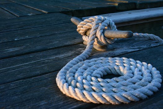 Întrebări Frecvente Platformă Joburi Maritime: Tot ce trebuie să știi despre carierele pe mare 2 Close-up of a sturdy nautical knot on a weathered wooden dock at sunset.