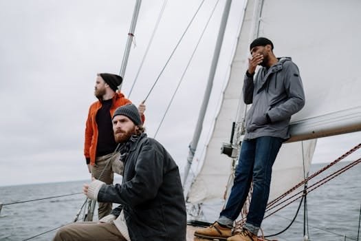 Șefi Mecanici Nave Angajări 2026: Studiu de Caz Exclusiv – Cum Am Triplat Aplicările! 3 Three men enjoy a thrilling adventure on a sailing boat, captured amidst the ocean's expanse.