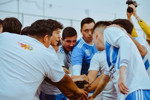 A soccer team huddles energetically before a game, showcasing unity and teamwork.
