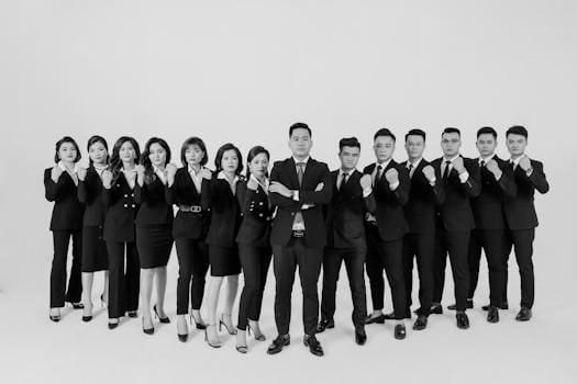 Group of professionals in business attire posing confidently in a studio setting.