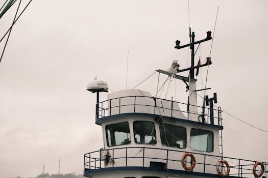 Close-up view of ship's bridge against a cloudy sky, showcasing nautical architecture.