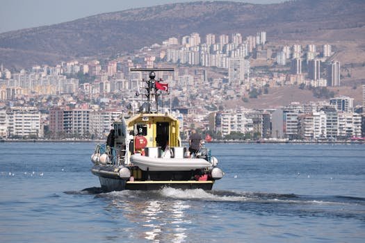 Cum să Alegi Cursul Certificat GMDSS București pentru Ofițeri Avansați 4 A scenic boat journey in İzmir Gulf with a city skyline backdrop in Türkiye.