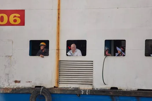 Cum să Alegi Lungimea Optimă a Contractului de Navigație Maritimă pentru Marinari 2 A diverse group of people looking out from ship windows in Ho Chi Minh City, Vietnam.