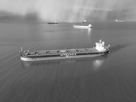 Aerial black and white photo of cargo ships on the sea near Vancouver, Canada, highlighting maritime traffic and trade.