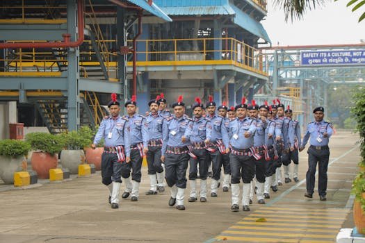 Security personnel in uniform performing a synchronized march at an industrial facility.