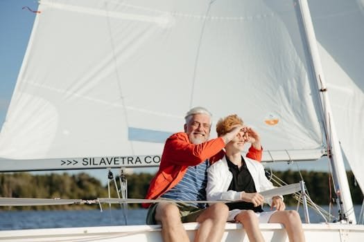 A joyful moment on a sailboat with grandfather and grandson bonding on a sunny day.