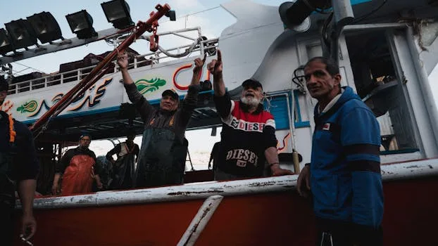 Fishermen aboard a colorful boat expressing joy after a successful fishing trip.