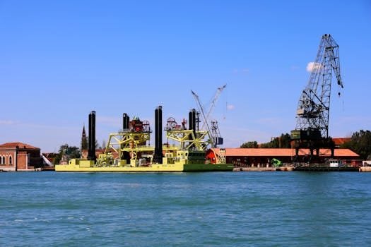 Probleme Frecvente în Contractele de Naviagție pentru Ofițeri de Punte și Cum să le Abordezi 2 View of industrial watercraft and cranes against the historic backdrop of Venice, Italy.