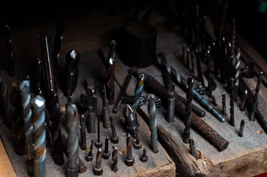 Cum să Abordezi Problemele Frecvente de Angajare Marinari Offshore prin Agenții de Recrutare Experte 2 Collection of various drill bits on a wooden board, ideal for metalwork and woodworking.
