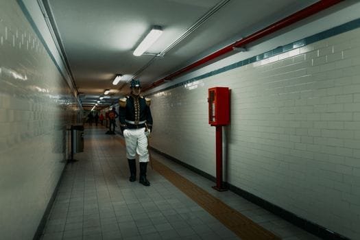 Cum să Alegi Cursul Ofițer Punte Diploma Acreditată: Compararea Ofertei Educaționale 3 A uniformed guard walks through a tiled subway tunnel in Buenos Aires, Argentina.