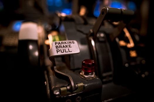 Cum să Compari Agențiile Crewing Marinari pentru a Alege Contractul de Navigație Potrivit 4 Detailed view of an aircraft parking brake lever with selective focus in a cockpit.