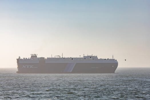 Cum să Obții Avantaje din Contractele Scurte pe Tancuri Petroliere ca Ofițer Maritim 4 Large cargo ship sailing on a calm ocean at sunset, clear sky above.