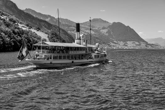 Cum să Obții Certificarea GMDSS și Să Avansezi în Cariera Maritimă din România 4 Vintage steamboat cruising on Lake Lucerne with scenic mountain backdrop. Black and white photography.