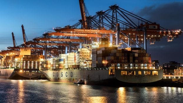 Ghid Complet: Cele Mai Bune Servicii de Recrutare Ofițeri Punte prin Agenții Crewing 4 Vibrant evening view of cargo operations at Terminal Burchardkai, Hamburg.