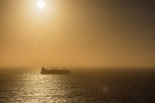 Recenzii Alegerii Recomandărilor Cursuri Radio Operator Maritim România 2026 2 A serene view of a ship silhouetted against the setting sun over the ocean.