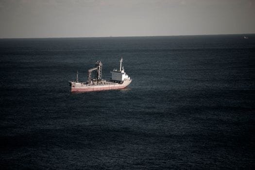 Recenzii Alegerii Recomandărilor Cursuri Radio Operator Maritim România 2026 3 Cargo ship navigating in the tranquil waters off the coast of Donghae-si, South Korea.