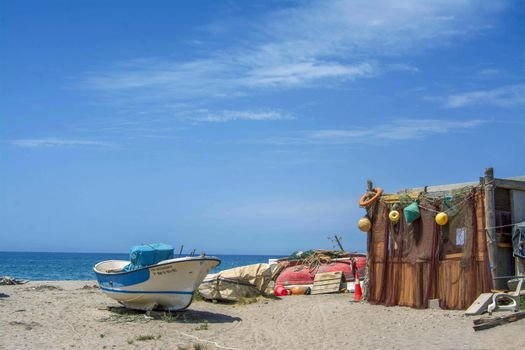 Ce Certificări sunt Esențiale pentru Marinarii Români care Caută Contracte de Navigație pe Timp de Vară 2026? 3 Peaceful beach scene with a fishing boat and rustic cabin in Cabo de Gata, Spain.