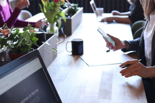 Contracte de Navigație Sezonieri vs Pe Termen Lung: Care este Alegerea Potrivită pentru Marinarii Români? 4 Contemporary office environment featuring teamwork with laptops, coffee, and greenery.