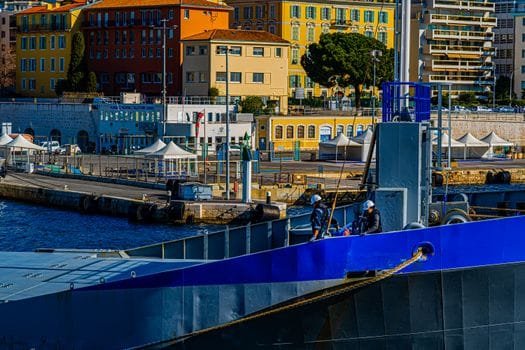 Vibrant harbor scene with a docked ship and colorful buildings under a sunny sky.
