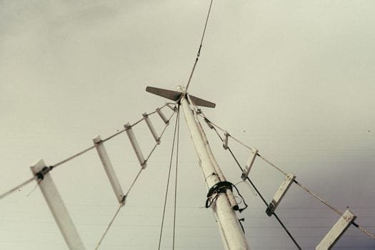 Artistic shot looking up at sailboat rigging with an abstract composition against a cloudy sky.