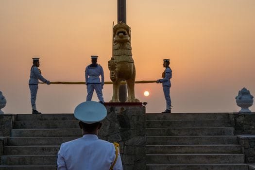 De ce Stabilitatea Joburilor Maritime pentru Ofițerii Români nu e un Mit în 2026 2 Sri Lankan naval officers conducting a flag ceremony at sunrise in Colombo.