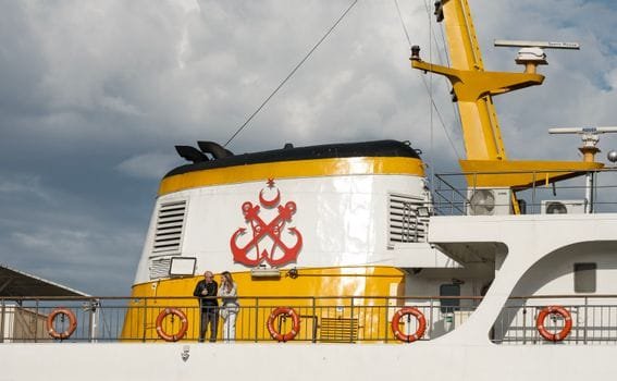 Ferry chimney with anchor symbols in Istanbul, under cloudy sky.