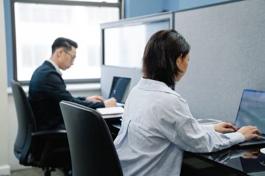 Adevărul despre Digitalizare: Nu Înlocuiește Nevoia de Recrutare Umana pentru Ofițerii Români în 2026 4 Two professionals working on laptops in a modern office cubicle setup.