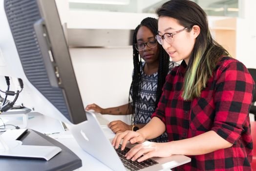 Ce întrebări atipice pot apărea la interviul pentru cadet inginer în august 2026? 2 Two female developers collaborating on a project in a modern office setting.