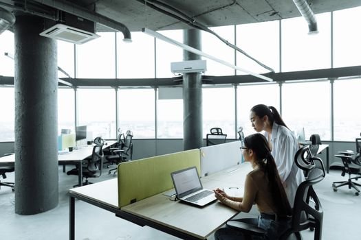 Ce întrebări atipice pot apărea la interviul pentru cadet inginer în august 2026? 3 Two Asian women collaborating in a modern office environment focused on teamwork and innovation.
