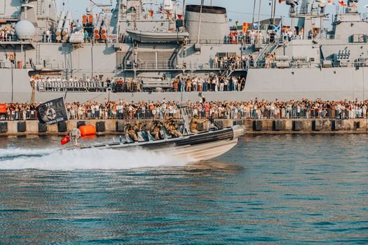 Cum influențează agențiile de crewing din Constanța obținerea de 'navigator jobs' pe termen lung? 2 Navy ship parade with maritime forces and a large spectator crowd.