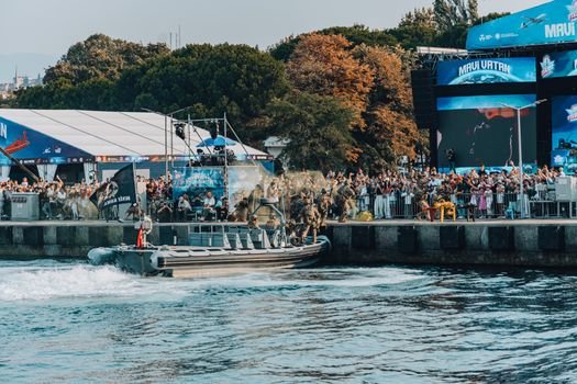 Cum influențează agențiile de crewing din Constanța obținerea de 'navigator jobs' pe termen lung? 3 Spectators watch a military demonstration at a lively outdoor festival event with a boat and large crowd.