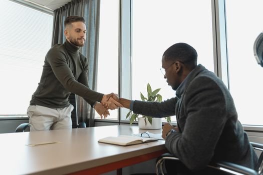 Cum și-a Găsit Ana un Înviorător Contract de Vară ca Ofițer de Mașină prin Agenții de Crewing din România, August 2026 2 Two businessmen shaking hands in a modern office after a successful meeting or interview.