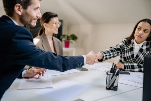 Cum și-a Găsit Ana un Înviorător Contract de Vară ca Ofițer de Mașină prin Agenții de Crewing din România, August 2026 3 A group of diverse professionals engaged in a business meeting and handshake in a modern office.