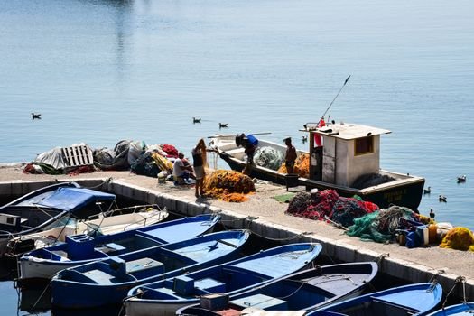 Top 5 Oportunități de Joburi în Catering la Bordul Navelor pentru August 2026 2 A vibrant harbor scene in Apulia, Italy with fishing boats and nets on a sunny day.