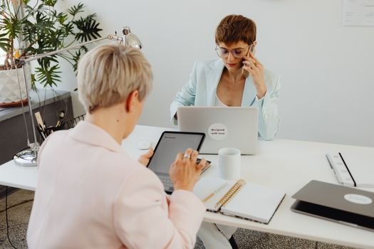 Cele Mai Importante 6 Certificări Navale pentru Cariera Ta pe Mare în Septembrie 2026 3 Professional women working on laptops and tablets in a modern office setting, focused on teamwork.