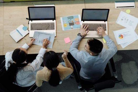 Navigație pe Marină Comercială vs Navigație de Croazieră: Care Sunt Oportunitățile pentru Joburi Maritime Toamna 2026? 3 Three colleagues working on laptops and documents at a desk, collaborating on business projects.
